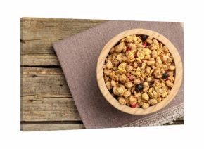 Tasty granola with dried fruits in bowl on wooden table, top view. Space for text