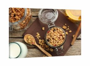 Tasty granola with dried fruits, milk and honey on wooden table, flat lay
