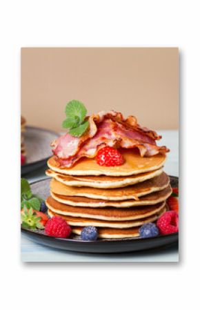 Fluffy pancakes with bacon, poached eggs and berries