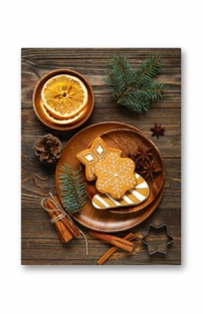 Plate with tasty Christmas cookies and decor on brown wooden background