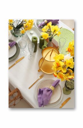 Beautiful table setting with daffodils and candles for wedding celebration in room, top view