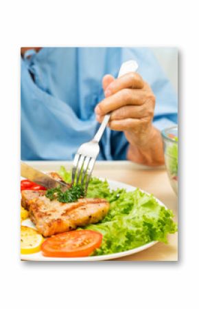 Asian senior woman patient eating pork chop stake and vegetable salad for healthy food in hospital.