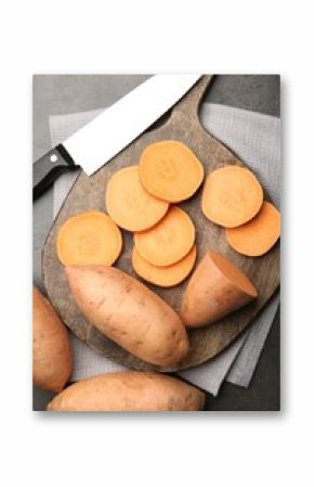 Fresh raw sweet potatoes and knife on gray table, top view