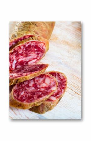 Popular Spanish salchichon sausage sliced on wooden background