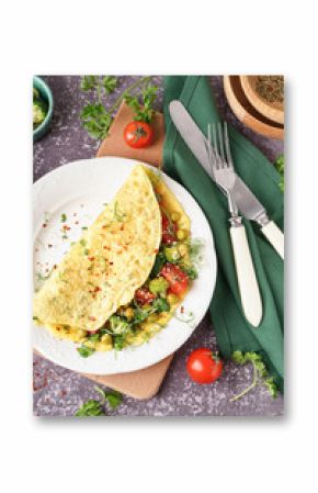 Tasty omelet with vegetables on grey grunge background