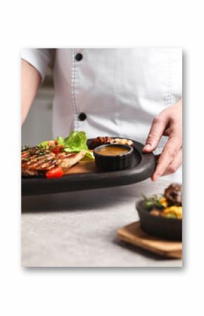 Professional chef serving dish at table indoors, closeup
