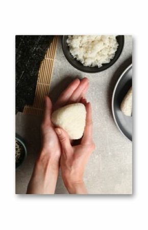 Woman making tasty onigiri (Japanese rice balls) at light table, top view