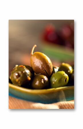 Olives, homemade marinated colorful olives with herbs and spices on rustic table, close up. Healthy Mediterranean vegan food. 