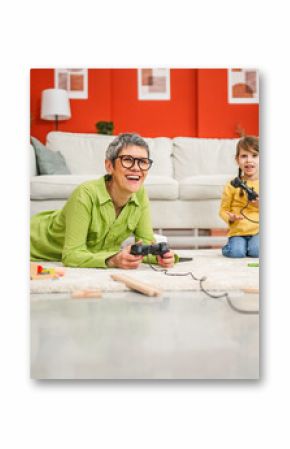 grandma and grandchild lying on floor and play video games with joystick