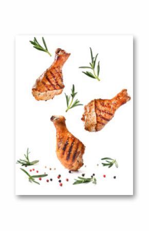 Grilled chicken legs or drumsticks falling down with herbs and colourful peppers isolated on white background. Juicy BBQ chicken drumsticks sprinkled with herbs and seasoning on white background..