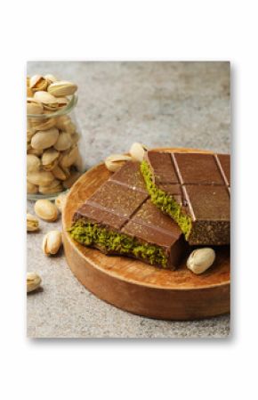 Pieces of Dubai chocolate bar with pistachios and knafeh on grey table