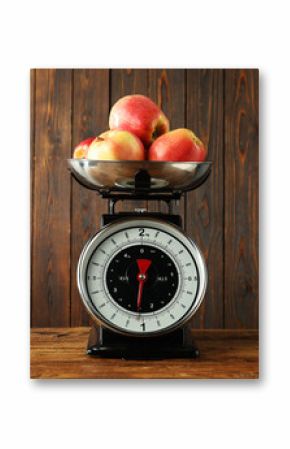 Retro mechanical kitchen scale with apples on wooden table