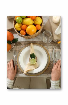 Young woman at served table prepared for dinner in room. Closeup