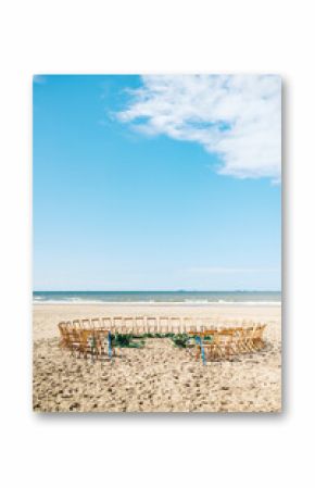 Circle of wooden folding chairs on the beach for a wedding ceremony with sea view