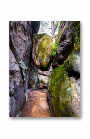 Stuck sandstone boulder above narrow pass in Besedice Rocks, Bohemian Paradise, Czech Republic