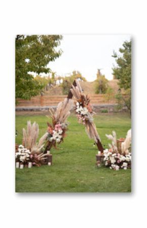 Triangular wedding arch. Wedding ceremony in boho style. Fresh flowers arrangements. Wedding day.