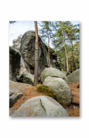 The picturesque landscape at Besedice Rocks showcases vibrant autumn colors with mossy boulders, towering trees, and unique rock formations, creating a serene natural environment.