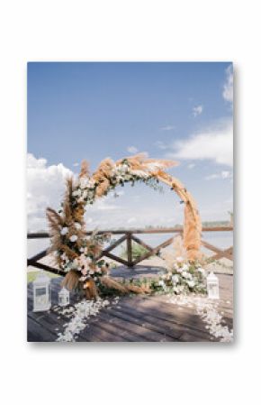 wedding round wooden arch with flowers on the pier