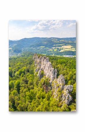 Panoramic view of the dry rocks of Suche skaly in Bohemian Paradise, Czechia. The sandstone formations rise dramatically from the lush green forest, creating a breathtaking landscape.