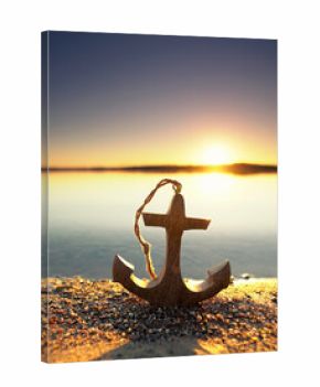 wooden anchor at the beach in warm autumn light