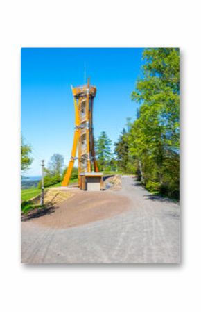 The Hamstejn lookout tower stands tall with its spiral staircase and steel structure, surrounded by lush greenery in Bohemian Paradise, Czechia, inviting visitors to enjoy scenic views.