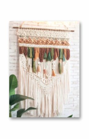 Handcrafted macrame wall hanging adorning a modern bohemian interior with houseplants and soft natural lighting