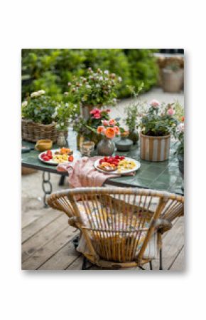 Beautifully decorated table with breakfast and flowers at garden
