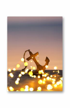 Seaside Serenity: Wooden Anchor and Glowing Lights at Sunset