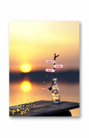 a bottle with light string on a small wooden pier in sunset light