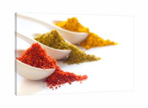 Spices in wooden spoons on a white background closeup