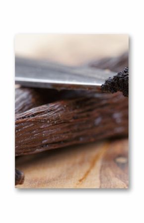 vanilla pod on olive board with beans on knife