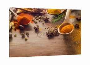 Various spices and herbs on wooden board.