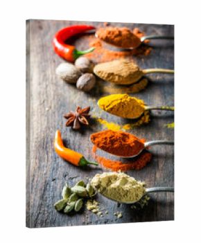 Tasty herbs and spices on old spoons