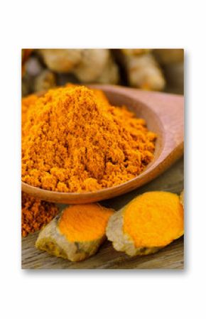 Turmeric and turmeric powder on wooden background