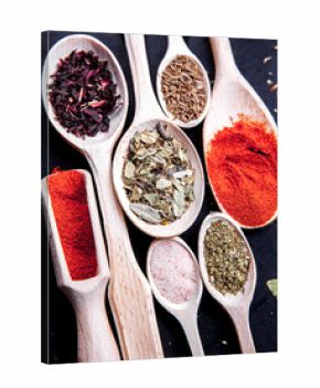 spice in wood spoon on a black background. food