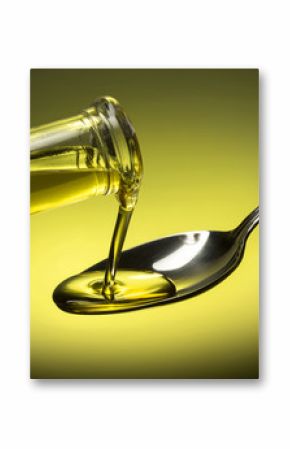 bottle pouring oil in a spoon on green background