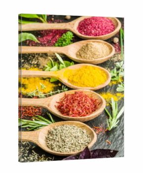 Assortment of colorful spices in the wooden spoons.