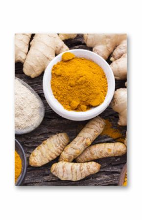 Powder and ginger root on curcuma powder and wood      