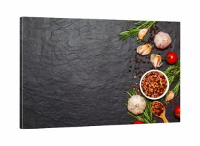 Colorful spices in spoons and tomatoes on dark vintage background. Top view. Food and cuisine ingredients.