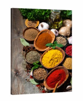 assortment of oriental spices on a wooden background, vertical top view