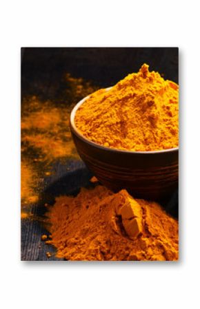 Composition with bowl of turmeric powder on wooden table