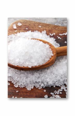 sea salt with wooden spoon and crystals of salt on wooden background.