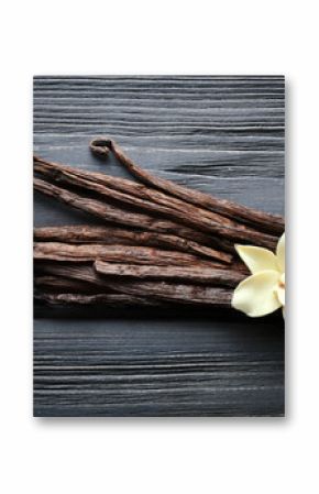 Vanilla sticks and flower on wooden background