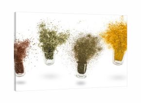 glass jars with various spices flying on white background