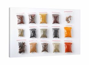 Plastic bags with different spices on white background, top view