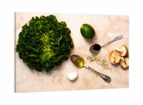 Head of lettuce with lime, oil, garlic and mushrooms on white marble