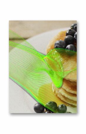Showcasing stack of golden pancakes on wooden table, with blueberries, mint leaf and neon overlay