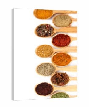 Assortment of spices in wooden spoons, isolated on white