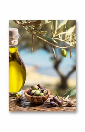 Oliwa z oliwek i jagody są na drewnianym stole pod oliwką