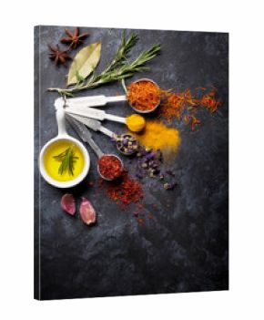 Herbs and spices over black stone